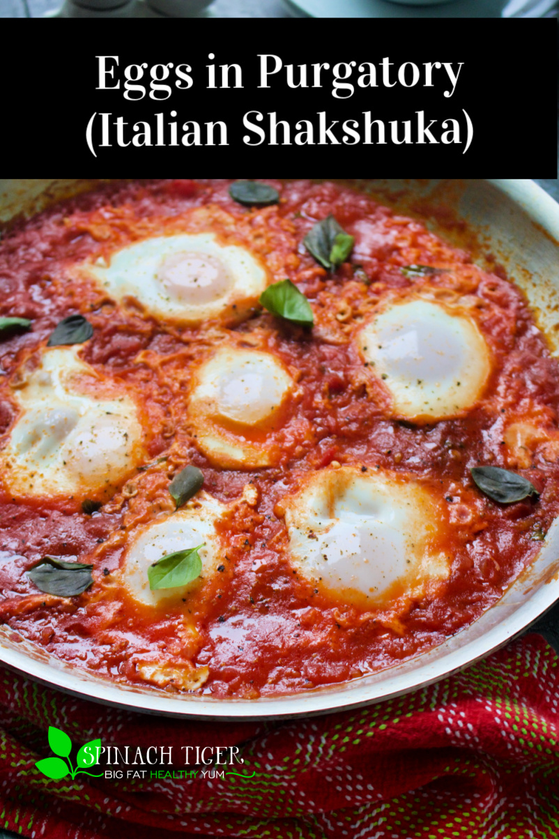 Eggs in Purgatory, (Italian version of shakshuka) softened eggs, nestled in easy, fast spicy tomato sauce. This entire dish takes about 25 minutes to make. #poachedeggs #eggdish #eggrecipe #tomatosauce #spinachtiger via @angelaroberts
